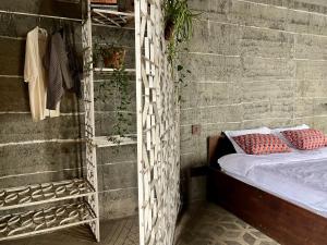 een bed met rode kussens erop in een bakstenen muur bij Community Lodge Nepal - Chhimeki Lodge in Nagarkot