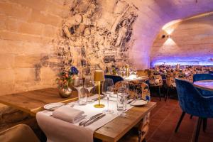 une salle à manger avec des tables et des chaises et un mur en pierre dans l'établissement Hotel Kasteel Oost, à Fauquemont
