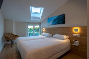 ムンダカにあるApartamentos&Spa Mundakaportの窓のある大きな白いベッドのある寝室 +61枚の写真