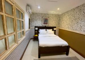 a bedroom with two beds in a room with windows at Retreat Cameroon BASTOS in Yaoundé +65 photos