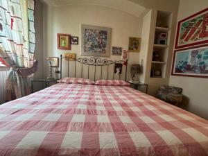 a bedroom with a bed with a red and white blanket at All'ingresso delle antiche mura della città in San Marino +6 photos