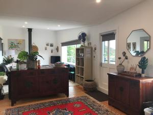a living room with a dresser and a mirror at The Seaside Studio Retreat in Wye River