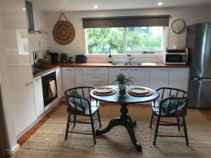 a kitchen with a table and two chairs and a sink at The Seaside Studio Retreat in Wye River