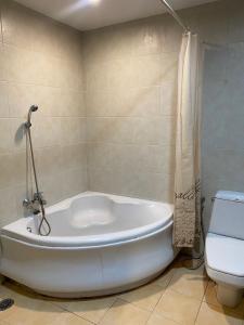 a white bath tub in a bathroom with a toilet at Lifeup care and hotel in Ban Mai