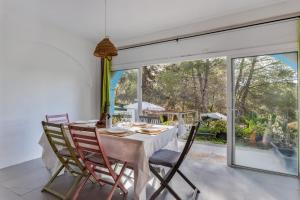 Un comedor con mesa y sillas y una gran ventana. en Villa Montecristo, en Montecristo