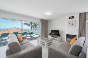 ein Wohnzimmer mit Sofa und Fernseher in der Unterkunft OurMadeira - Arco Sun in Arco da Calheta