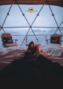 eine Person, die auf einem Bett mit erhobenen Füßen liegt in der Unterkunft SADEM WADl RUM in Wadi Rum