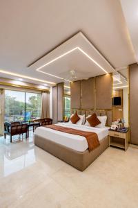 um quarto grande com uma cama grande e uma secretária em Hotel Downtown - East of Kailash em Nova Deli