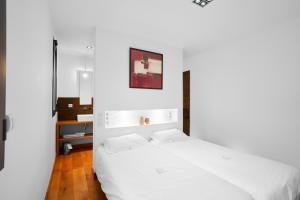 une chambre blanche avec un grand lit blanc avec des draps blancs dans l'établissement Loft Ôvebas - Domaine De L 'ô, à Bellacaud 25 autres photos