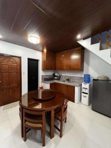 a kitchen with a wooden table and a kitchen with a sink at BALAI MALINAWON - Balai 3 in General Luna