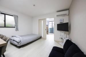 a living room with a bed and a couch at Villetta Imari Ekimae III Room 104 - Vacation STAY 19028 in Imari