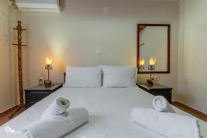 a bedroom with a large white bed with towels on it at Myrsini's House - Neapoli Garden & Grove Retreat  +46 photos
