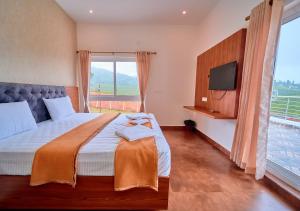 a bedroom with a large bed and a television at Cucuu Nest Villa Coonoor by VOYE HOMES - Surrounded by Tea Plantations in Coonoor