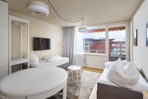 una habitación blanca con una cama y una mesa en Studio 700hm Schruns, en Schruns