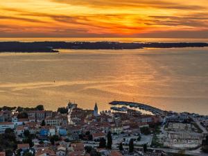 - une vue sur la ville et l'océan au coucher du soleil dans l'établissement Villa Palatium III in Fažana for 8 people only 200 meters from the sea with sauna & indoor-outside heated pool, à Fažana 44 autres photos