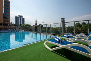 a large swimming pool with lounge chairs on a balcony at Golden Tulip Canaan Kampala in Kampala
