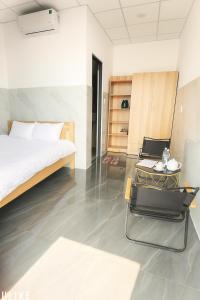 a bedroom with a bed and a table and chairs at Ánh Mai Hotel in Bao Loc +40 photos