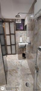 瓦拉纳西Shree Shanteshwar Mahadev Inn的带淋浴、水槽和马桶的浴室