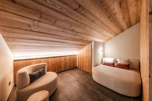 a room with a bed and a chair in it at El Giof Alpine Home in Pellizzano