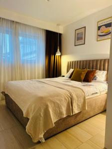 a large bed in a bedroom with a window at White Shell Sarajevo - Cozy & Stylish Apartment in Old Town in Sarajevo