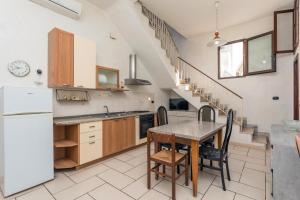 a kitchen with a table and a staircase at A Casa Mia in Riposto
