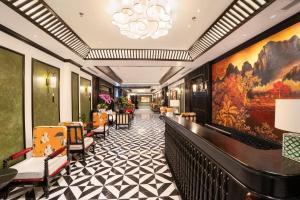 a corridor of a hotel with chairs and paintings at C'Lau Hotel Ninh Binh in Ninh Binh