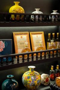 a shelf filled with different types of vases and pictures at C'Lau Hotel Ninh Binh in Ninh Binh