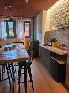 a kitchen with a wooden table and some chairs at Dolcevita guest house in Torreano