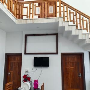a living room with a staircase and a tv at Sithara in Kannur