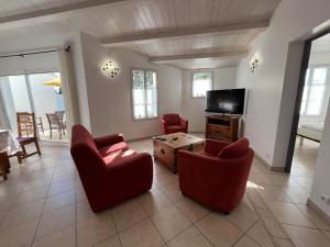 a living room with two chairs and a tv at Loizeau 3 chambres in Ars-en-Ré