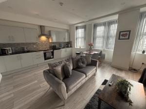 a living room with a couch and a kitchen at Modern and Spacious Home CITY CENTRE location and FREE parking in Bolton +35 photos