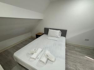 a bedroom with a bed with two towels on it at Modern and Spacious Home CITY CENTRE location and FREE parking in Bolton