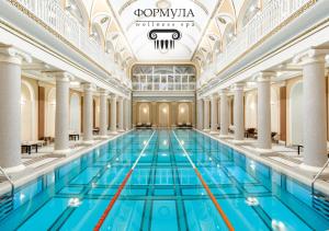 a large swimming pool in a building with columns at Hotel Bristol in Odesa