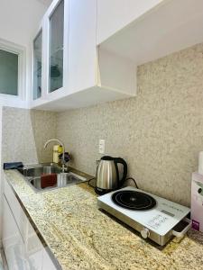 eine Küchentheke mit Herd und Spüle in der Unterkunft Homestay Máy chiếu vs Ban công ngắm thành phố - Marina Plaza in Ấp Ðông An (1)