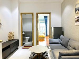 ein Wohnzimmer mit Sofa und Tisch in der Unterkunft Homestay Máy chiếu vs Ban công ngắm thành phố - Marina Plaza in Ấp Ðông An (1) + 5 Fotos