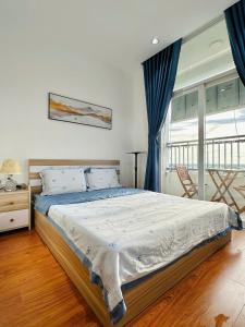 ein Schlafzimmer mit großem Bett und Fenster in der Unterkunft Homestay Máy chiếu vs Ban công ngắm thành phố - Marina Plaza in Ấp Ðông An (1)