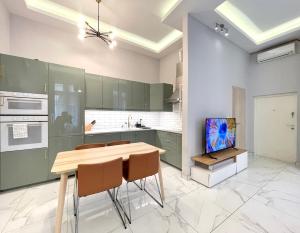a kitchen with green cabinets and a wooden table and chairs at 布达城堡链子桥公寓民宿 in Budapest