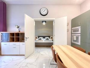 a kitchen with a table and a clock on the wall at 布达城堡链子桥公寓民宿 in Budapest +8 photos