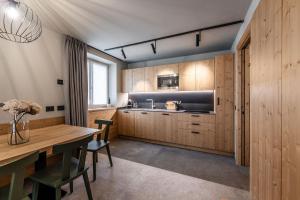 a kitchen with wooden cabinets and a wooden table at El Giof Alpine Home in Pellizzano +15 photos