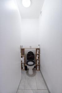 ein Badezimmer mit einem WC und einem schwarzen Sitz in der Unterkunft Chez Adrien au Haillan Appt rez de chaussée jardin in Le Haillan