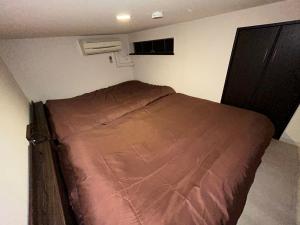 a small bedroom with a bed in a room at Guest House Ogusu INN in Fukuoka