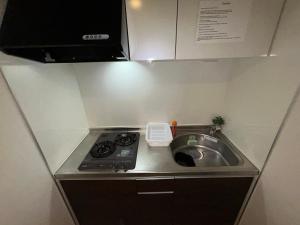 a small kitchen with a stove and a sink at Guest House Ogusu INN in Fukuoka +14 photos