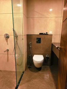 een badkamer met toilet en glazen douche bij Parays Fernwoods in Mannārakkāt