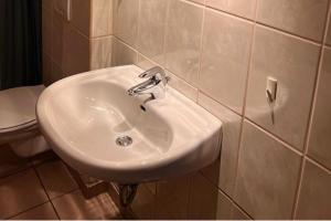 a white sink in a bathroom with a toilet at Beautiful 8 Bed Apartment in Hallenberg in Hallenberg