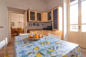 una cucina con un tavolo con una ciotola di arance sopra di San Lorenzo by the sea ad Augusta