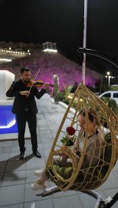 ハッタにあるChalet--J4--شاليهのブランコに乗った女性とバイオリンを弾く男性