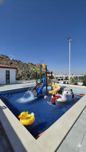 ハッタにあるChalet--J4--شاليهのウォーターパークのプールで人々が浮き輪に乗っている