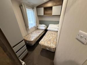 ein kleines Zimmer mit zwei Betten und einem Fenster in der Unterkunft Oscars Inn, West Sands, Seal Bay Resort in Selsey