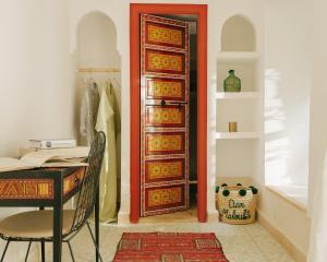a door in a room with a table and a desk at Riad dar Maloukti in Marrakesh