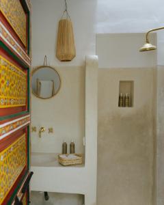 une salle de bain avec un lavabo et un miroir dans l'établissement Riad dar Maloukti, à Marrakech